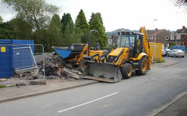 Yellow JCB 3CX backhoe loader on a UK street